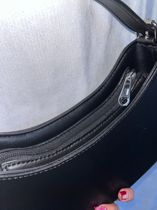 Titre produit :
Sac “Amara” – Noir élégant, détail cœur & bandoulière réglable