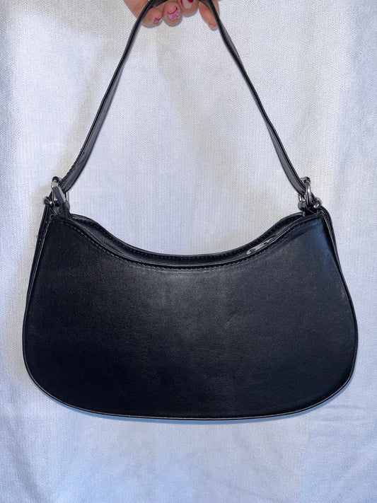 Titre produit :
Sac “Amara” – Noir élégant, détail cœur & bandoulière réglable